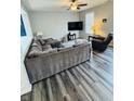 Inviting living room features gray wood floors, a plush sectional sofa, and a large-screen TV for entertainment at 8176 Crumwell Dr, Avon, IN 46123