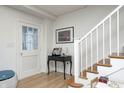 Inviting hallway features hardwood floors, white trim, and a staircase with natural wood treads at 8436 E 56Th St, Indianapolis, IN 46216