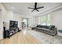 Bright living room featuring hardwood floors, a ceiling fan, and ample natural light at 8436 E 56Th St, Indianapolis, IN 46216
