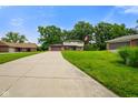 Charming home with a long driveway, green lawn, mature trees, and an American flag waving in the breeze at 955 Wood Creek Pl, Greenwood, IN 46142