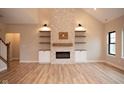 Bright living room featuring a modern fireplace, built-in shelves, and light wood flooring at O Legacy Estates-Lot 5, Mooresville, IN 46158
