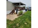 Cozy porch with wood railing, stairs, and brick pavers leading to a green lawn at 10129 Peartree Rd, Indianapolis, IN 46235