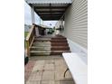 A covered porch with stairs, outdoor seating, and a partially painted steps at 10129 Peartree Rd, Indianapolis, IN 46235