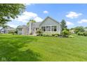 Spacious backyard showcasing green lawn, mature trees, and well-kept landscaping at 1051 Arrowwood Dr, Carmel, IN 46033
