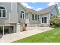 Exterior view of a home with a sliding glass door to a walkout basement and a stone patio at 1051 Arrowwood Dr, Carmel, IN 46033