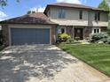 A view of the house and driveway with a well-manicured lawn and an attached two-car garage at 13736 Langley Dr, Carmel, IN 46032
