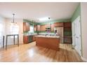 Open kitchen with stainless steel appliances, wood cabinets, an island and hardwood flooring at 1477 Macintosh Ct, Avon, IN 46123