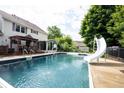 Backyard pool with a slide, pergola, and glassed-in room for outdoor entertainment and relaxation at 1477 Macintosh Ct, Avon, IN 46123