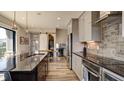 Beautiful kitchen with stainless steel appliances, an island with seating, and modern light fixtures overhead at 15958 Meadow Frost Ct, Fishers, IN 46037
