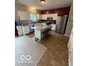 Open kitchen with a stainless steel refrigerator, white cabinets and island with granite countertops at 1711 Jaques Dr, Lebanon, IN 46052