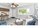 Bright living room featuring gray walls, wood accent wall, modern decor, plush seating, and large window at 1820 Hemlock Ln, Plainfield, IN 46168