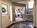 View of front door with hardwood floors, a staircase, and arched entryway into the living room at 2303 Eagle Brook Dr, Shelbyville, IN 46176