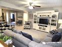 Spacious living room with a ceiling fan, built-in entertainment center, and comfortable seating arrangement at 2303 Eagle Brook Dr, Shelbyville, IN 46176