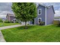 Blue sided two-story home with lush green lawn, driveway, and a mature shade tree in front at 2485 Bristol Dr, Franklin, IN 46131