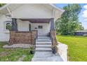 Welcoming front porch with brick accents and decorative flower pots to either side of the stairs at 2831 N Talbott St, Indianapolis, IN 46205