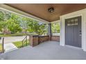 Covered front porch with brick accents and neutral gray door and ceiling at 2831 N Talbott St, Indianapolis, IN 46205