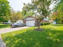 A charming single-story home with a well-maintained lawn, brick accents, and a two-car garage on a sunny day at 3303 Wedgewood Dr, Indianapolis, IN 46227