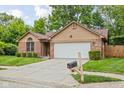 Attractive single-story home featuring a well-kept lawn, brick detailing, and an attached two-car garage at 3304 Fox Orchard Cir, Indianapolis, IN 46214