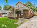 Inviting home displaying a quaint brick exterior, a covered porch, and a neatly kept lawn at 3558 N Gladstone Ave, Indianapolis, IN 46218