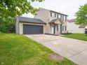 Charming two-story home with an attached garage, complemented by a well-maintained lawn at 3734 Lacebark Dr, Indianapolis, IN 46235