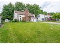 View of the home's exterior with green lawn and mature trees at 4382 Castlebay Way, Indianapolis, IN 46254
