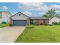 Attractive single-Gathering home with a lush green lawn and mature landscaping creating curb appeal at 488 Village Blvd, Mooresville, IN 46158