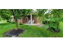 Quaint back porch with white chairs, lovely landscaping and a peaceful outdoor setting at 5189 Bally Bunion Dr, Avon, IN 46123