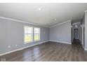Inviting living room featuring stylish hardwood floors, neutral paint, and ample natural light through the windows at 5515 W Morris St, Indianapolis, IN 46241