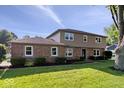 Beautiful two-story home with brick and siding, landscaped yard, and mature trees on a sunny day at 567 Hawthorne Dr, Carmel, IN 46033