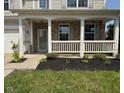 The front porch features white railings, brick pillars, and a small garden bed adding curb appeal at 5683 James Blair Dr, Indianapolis, IN 46234