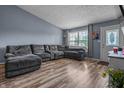 Comfortable living room with a plush sectional sofa, wood floors, and ample natural light at 5811 Simmul Cir, Indianapolis, IN 46221