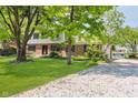 Inviting two-story home with a well-maintained lawn and a gravel driveway at 6146 Rucker Rd, Indianapolis, IN 46220