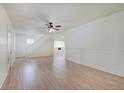 Open-concept living room with laminate wood floors, white trim, and staircase at 616 S Fuller Dr, Indianapolis, IN 46241