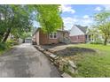 Cozy red brick home with a long driveway, a detached garage, and a well-kept lawn at 6477 N Park Ave, Indianapolis, IN 46220