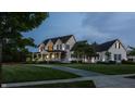 Expansive two-story home featuring a welcoming front porch and a sprawling lawn, illuminated by the glow of dusk at 6685 Chapel Xing, Zionsville, IN 46077