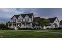 A beautiful two story white home with black shutters, a charming front porch, and a sprawling green lawn at dusk at 6685 Chapel Xing, Zionsville, IN 46077