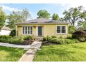 Quaint yellow home featuring a well-kept front yard and charming walkway at 713 W Cromer Ave, Muncie, IN 47303