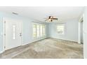 Bright living room with large windows, neutral carpet, and ceiling fan at 713 W Cromer Ave, Muncie, IN 47303
