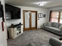 Comfortable living room with neutral tones, including a large TV and sliding barn door entertainment center at 719 Henry St, Lebanon, IN 46052
