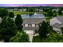 An aerial view of a beautiful home in a peaceful neighborhood, complete with a scenic pond and mature trees at 7214 Morello Ln, Noblesville, IN 46062