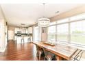 Bright dining area featuring wood floors, a rustic table with seating, and large windows offering natural light at 7214 Morello Ln, Noblesville, IN 46062