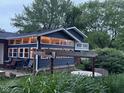 View of the home's rear exterior highlighting an enclosed sunroom, patio area, and hot tub at 75 Byram Blvd, Martinsville, IN 46151