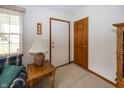 A bright foyer with tile flooring, a wooden door, and an adjacent seating area at 7632 Sea Crest N Way, Noblesville, IN 46062