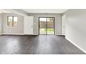 Spacious living room featuring luxury vinyl floors, a large sliding glass door, and fresh paint at 8545 La Corrida Ct, Indianapolis, IN 46227
