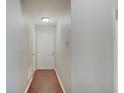 Hallway featuring hardwood floors, with a white door at the end and neutral-colored walls at 1074 Timber Creek Dr # 8, Carmel, IN 46032