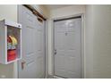 Hallway featuring two gray doors, one with a fire extinguisher, and a neutral color scheme at 1074 Timber Creek Dr # 8, Carmel, IN 46032