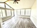 Sun-filled room with large windows, wood-look flooring, and a high ceiling with exposed beams at 10922 Snowdrop Way, Indianapolis, IN 46235