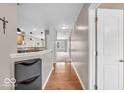 Hallway featuring hardwood floors leading to an open-concept kitchen at 11254 N Sashing Way, Monrovia, IN 46157
