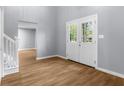 Bright foyer with light-gray walls, wood-look flooring, and a glass paneled front door at 1127 Junco Dr, Columbus, IN 47203