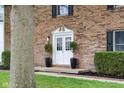 The facade of the brick home featuring a white double-door entry with black accents and green lawn at 1127 Junco Dr, Columbus, IN 47203